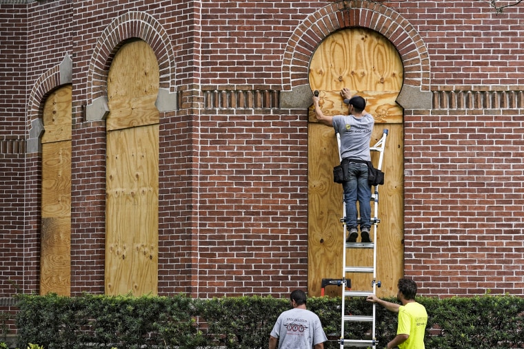 Workers from Specialized Performance Delivered 24:7 board up the windows on the historical Henry B. Plant Hall on the campus of the University of Tampa ahead of Hurricane Ian on Sept. 27, 2022, in Tampa, Fla.