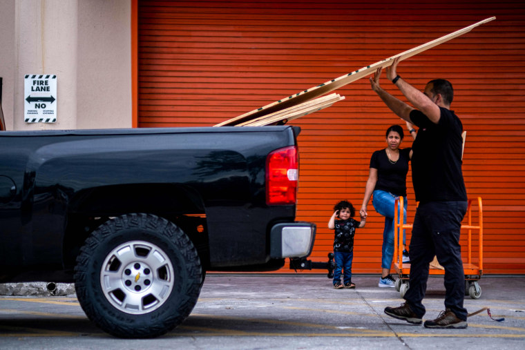 A man loads wood in his vehicle outside a Home Depot store in preparation for the arrival of Hurricane Ian in Tampa, Fla., on Sept. 27, 2022.