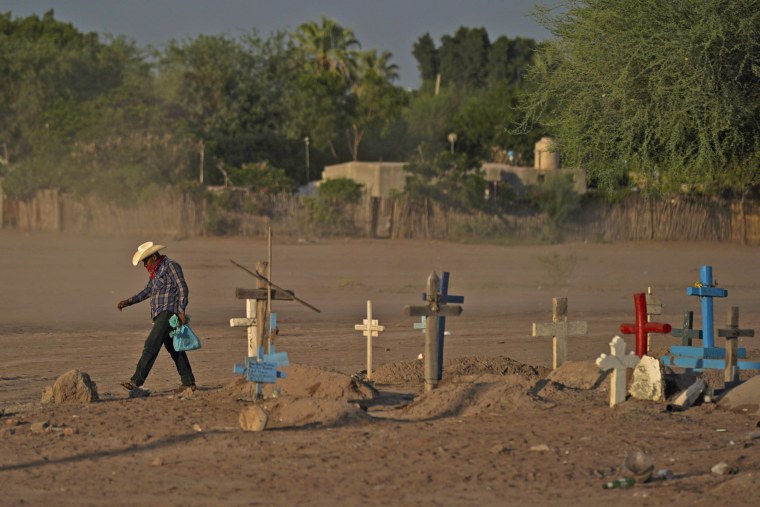 A Yaqui Indigenous man walks past the cemetery where slain water-defense leader Tomás Rojo is buried in Potam, Mexico, on Sept. 27, 2022.