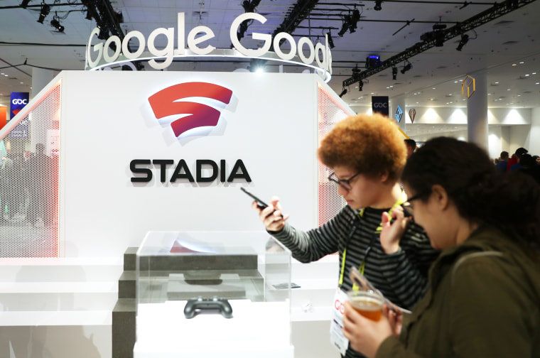 Attendees look at a Stadia controller
