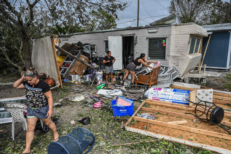Residents of mobile homes clean up debris in the aftermath of Hurricane Ian