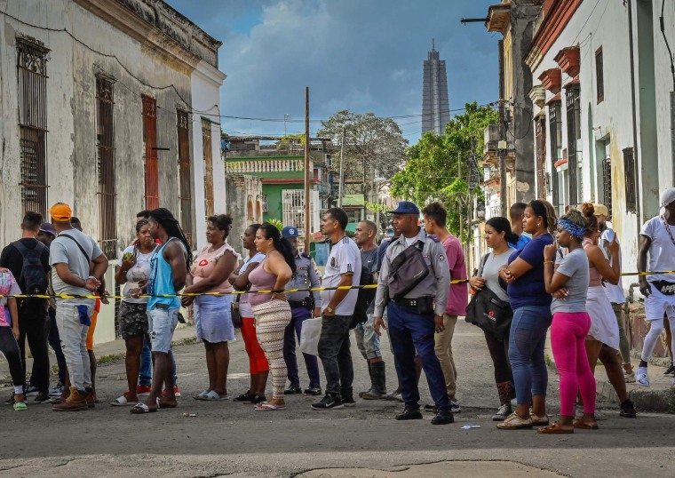Kerumunan menyaksikan kabel listrik dipulihkan setelah beberapa hari tanpa listrik di El Cerro, Kuba.