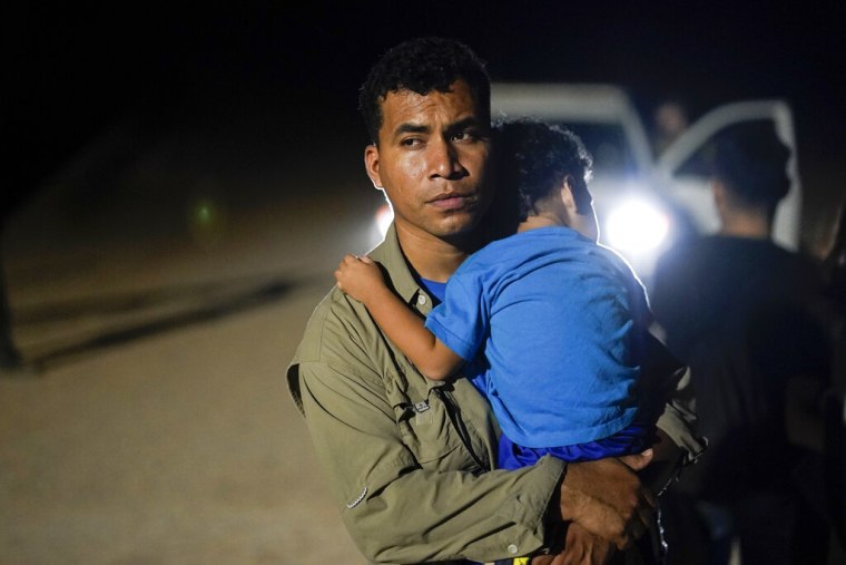 Un migrante y su hijo mientras esperan ser atendidos por los agentes de la Patrulla Fronteriza.