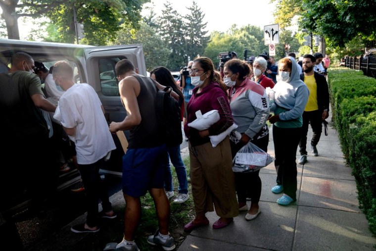 Migrantes de Venezuela, que abordaron un autobús en Texas, esperan a ser transportados a una iglesia local por voluntarios después de ser dejados fuera de la residencia de la vicepresidenta estadounidense Kamala Harris, en el Observatorio Naval en Washington, DC, el 15 de septiembre de 2022.