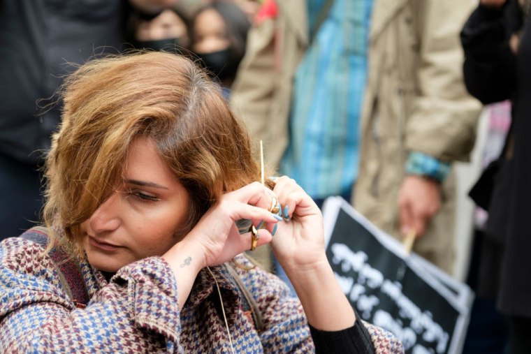Una mujer iraní se corta el pelo durante una protesta contra el régimen en Bruselas, el 23 de septiembre de 2022.