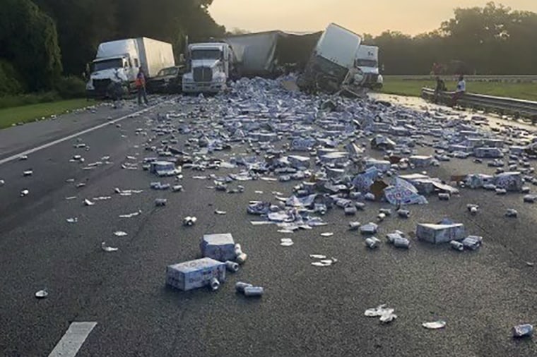In this photo provided by Florida Highway Patrol, cases of Coors Light beer are strewn across a highway after two semitrailers collided on a Florida highway on Wednesday, Sept. 21, 2022, near Brooksville, Florida.