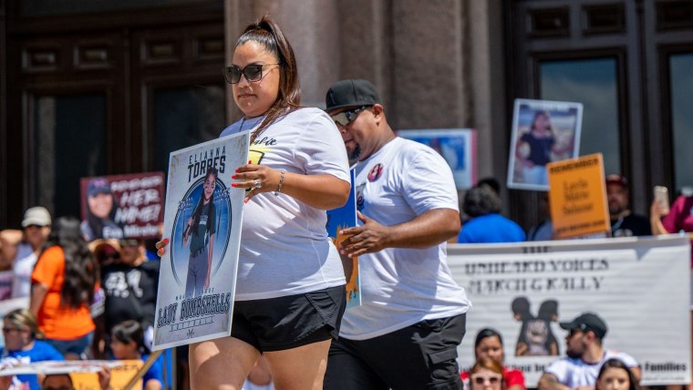 Familiares de Eliahna Torres, una de las niñas que un tirador asesinó en Uvalde, sostienes pancartas con fotos de la menor en una protesta en el Capitolio de Texas, en Austin