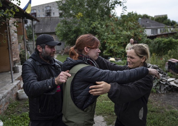María, centro, abraza a sus padres Marina y Alexander durante su primer encuentro después de siete meses desde el comienzo de la guerra en la ciudad recientemente recuperada de Izium, Ucrania, el miércoles 14 de septiembre de 2022.