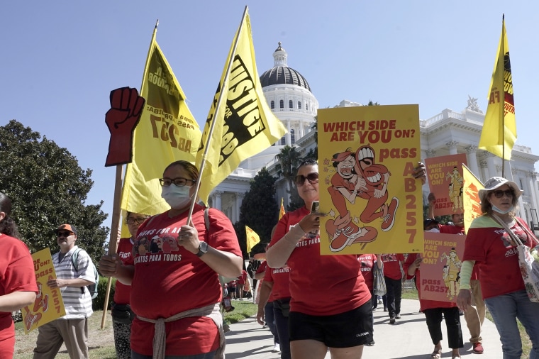 Fast-food workers and their supporters march past the state Capitol calling on passage of a bill to provide increased power to fast-food workers, in Sacramento, California on Tuesday, Aug. 16, 2022.