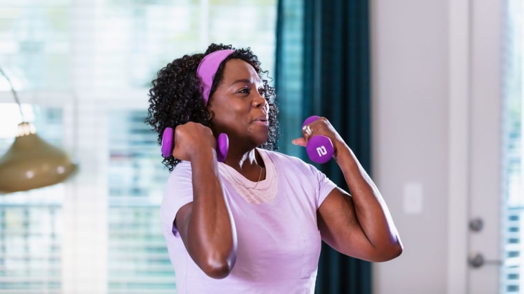 Woman breathing out during bicep curls