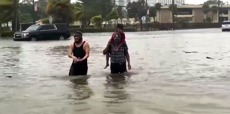 Residents of Fort Myers, Florida, make their way through floodwaters caused by Hurricane Ian.