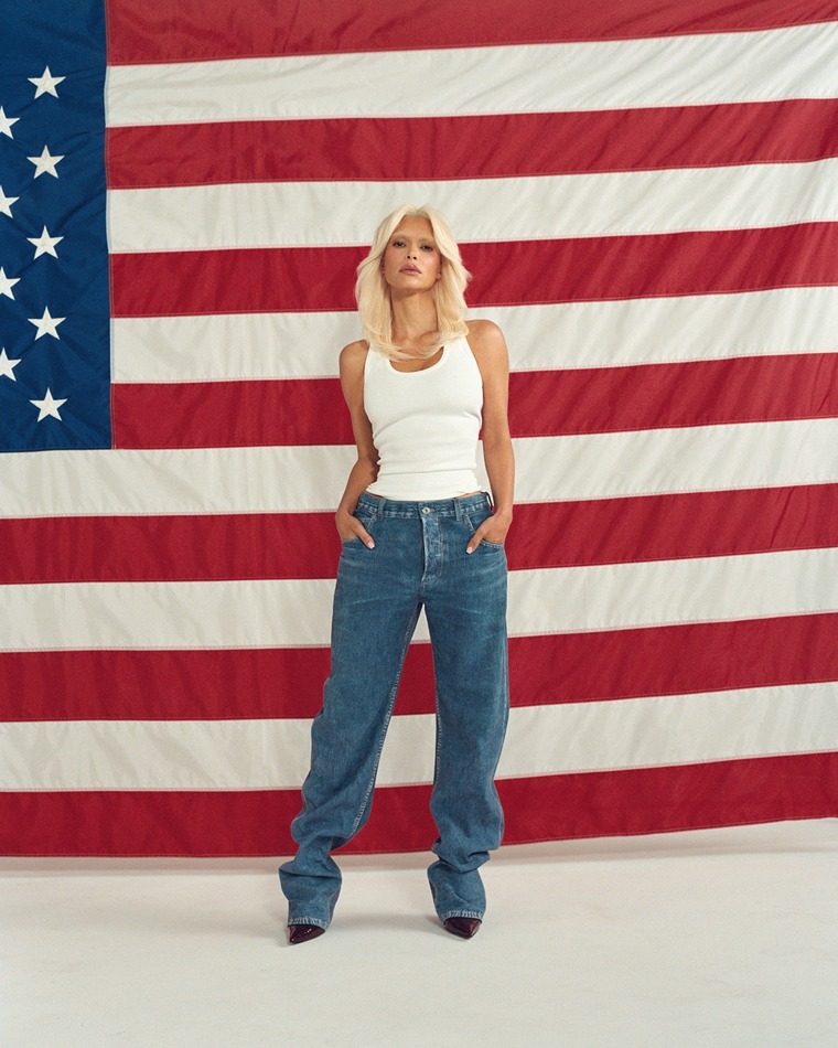 Kardashian poses in front of the American flag.