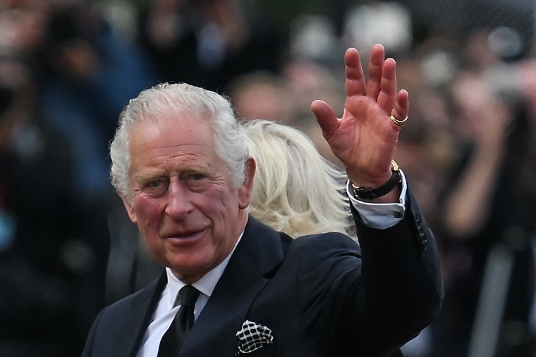 Britain's King Charles III and Britain's Camilla, Queen Consort greet the crowd upon their arrival Buckingham Palace.