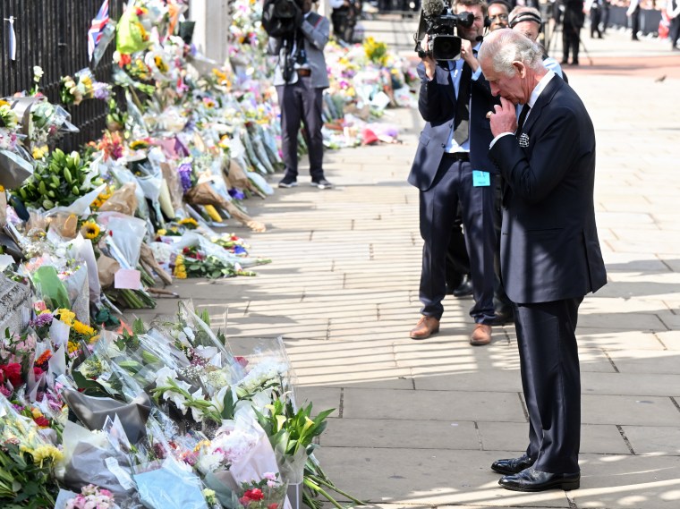 King Charles III views floral tributes to the late Queen Elizabeth II outside Buckingham Palace.