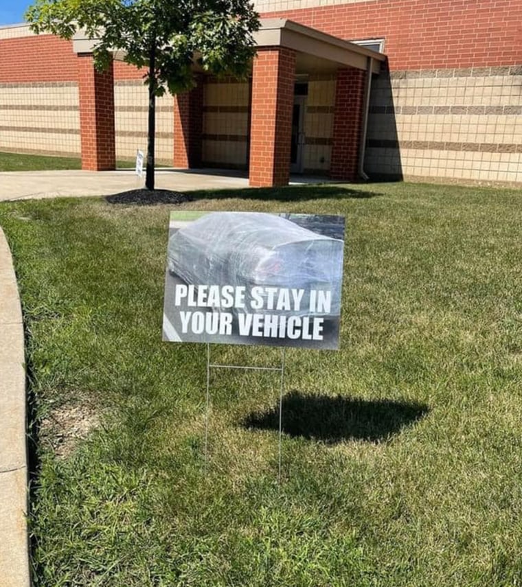 A sign directing parents to stay in their cars during morning drop-off was a hit with moms and dads.