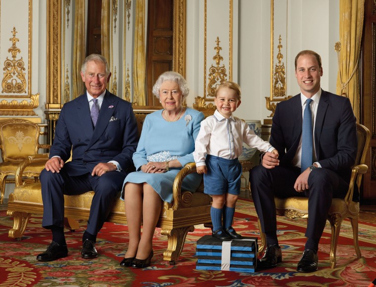 Image: Prince Charles, Prince of Wales, Queen Elizabeth II, Prince George, and Prince William, Duke of Cambridge smiling in the White Drawing Room at Buckingham in London in 2015.