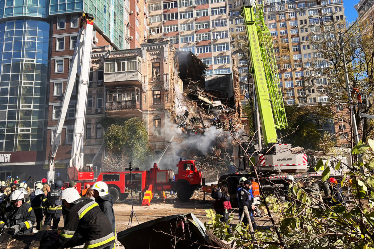 Rescue workers search for survivors after a drone attack on a residential building in Kyiv on Monday. 