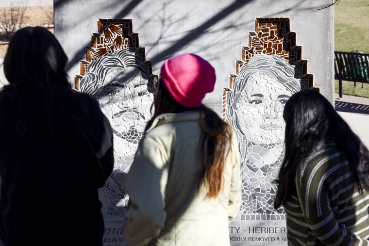 University of Colorado students look at the Los Seis de Boulder monument