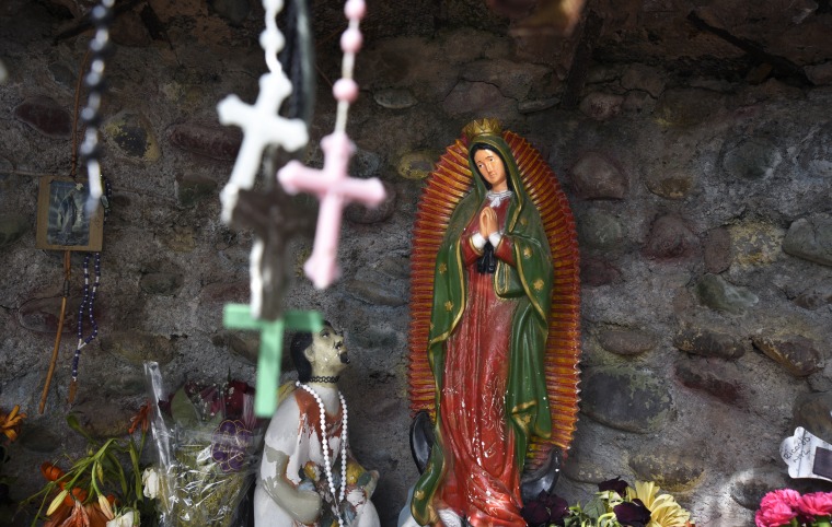 A statue of Our Lady of Guadalupe is among items left by worshippers in a shrine in Chimayo, New Mexico, in 2018.