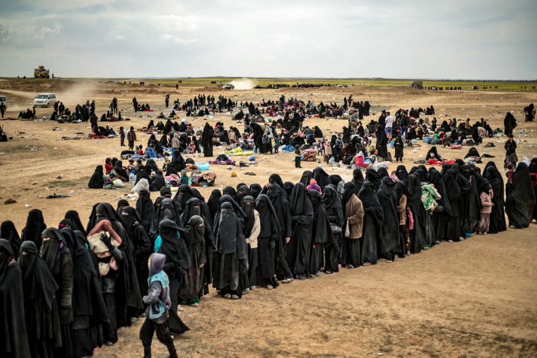 Des femmes et des enfants font la queue à un point de contrôle alors que des centaines de civils, qui ont fui le dernier bastion syrien du groupe État islamique, arrivent dans une zone dirigée par les Forces démocratiques syriennes soutenues par les États-Unis à l'extérieur de Baghouz, dans la province syrienne orientale de Deir Ezzor, le 5 mars. 2019.