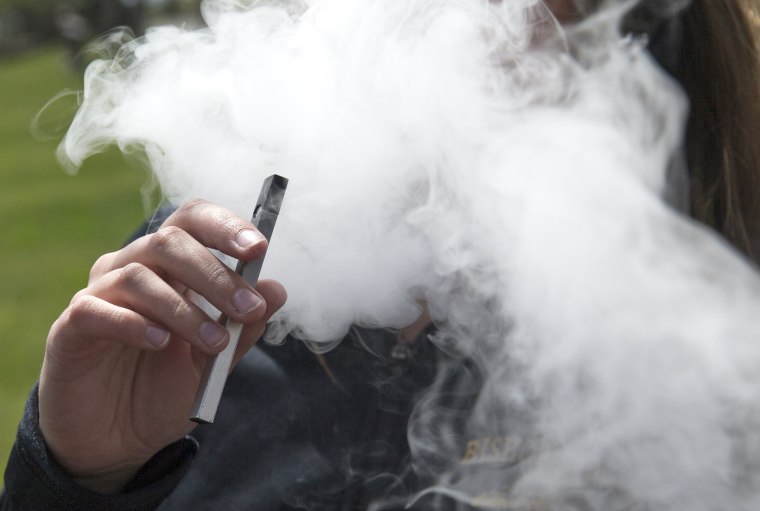 A person smokes an e-cigarette in Oakland, Calif., in 2018.