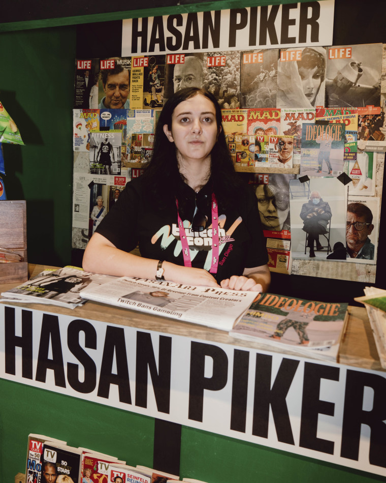 Sorrenti poses at Hasan Piker's TwitchCon newsstand themed booth.