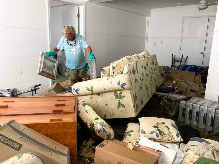 Image: Resident Pamela Brislin who has lived on Sanibel Island since 2020 cleans up the damage from Hurricane Ian, on Oct. 6, 2022, in Sanibel Island, Fla.