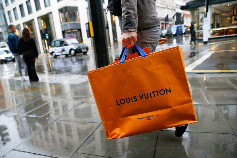 A shopper carries a Louis Vuitton shopping bag on New Bond Street in London
