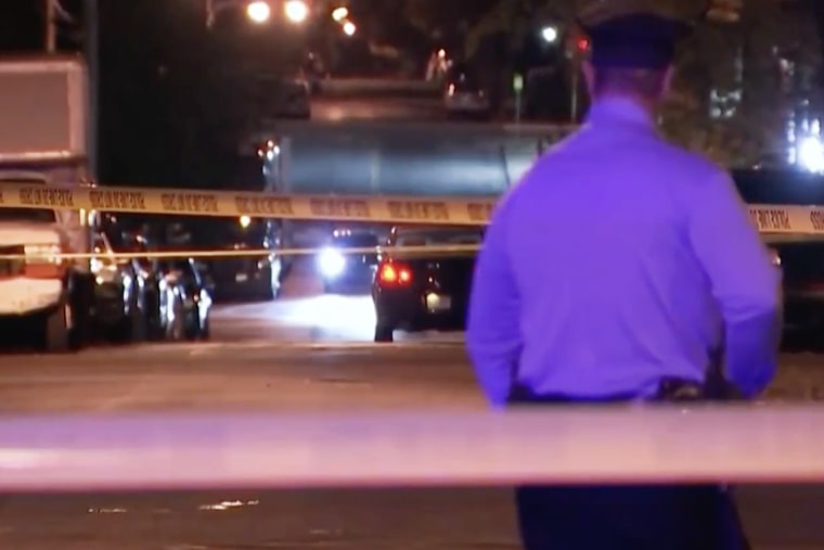 An officer guards the scene where a 13-year-old boy was shot multiple times in the head in Philadelphia on Monday. 