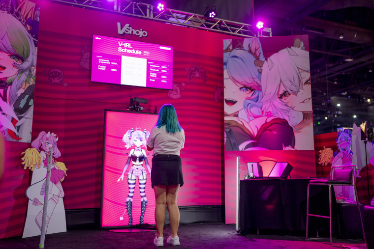 A fan stands at the VShojo booth to meet the Vtuber Ironmouse.