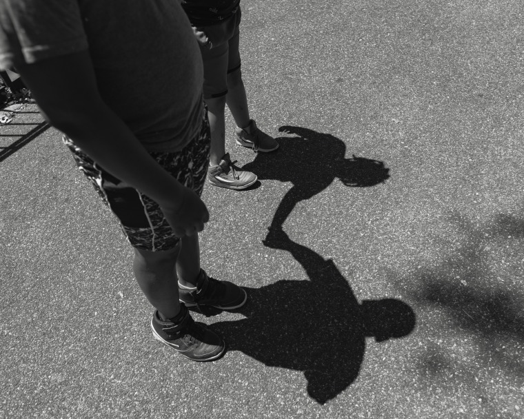 Shadows of two boys holding hands.