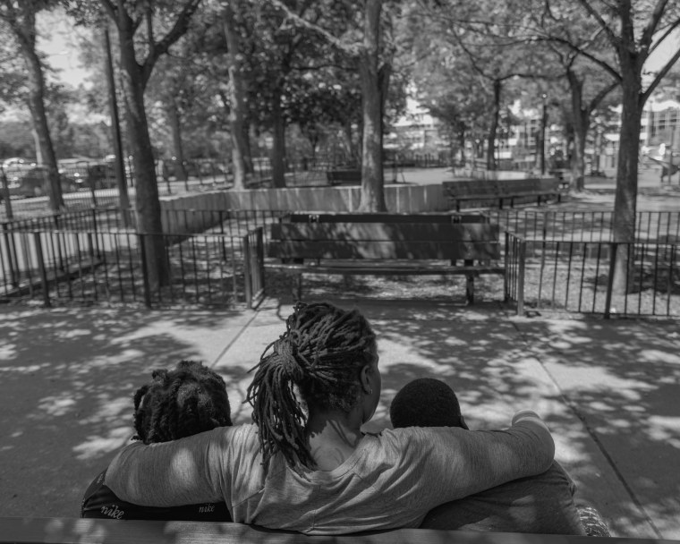 Ronisha and her sons sitting at a park near her their home