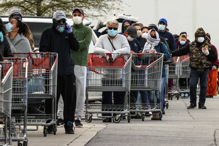Customers wear face masks to prevent the spread of the novel coronavirus as they line up to enter a Costco Wholesale store April 16, 2020 in Wheaton, Md.