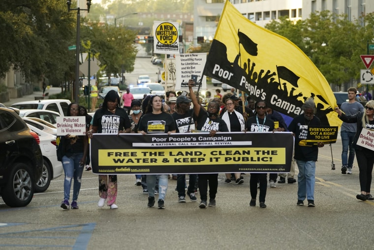 More than 200 Jackson residents and supporters hold signs as they march to the governor's mansion to protest water issues in the city. 