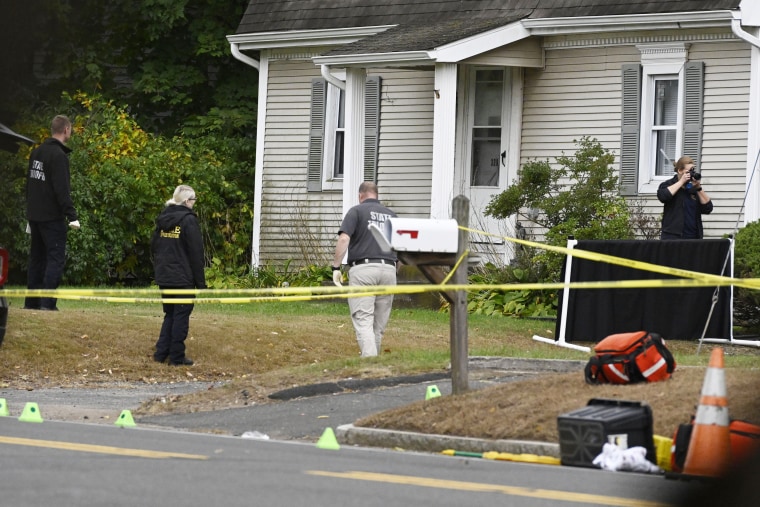 Police investigate the scene where two police officers were killed