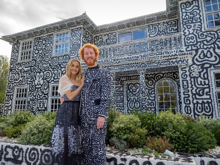 Artist Sam Cox and his wife, Alena, outside their house.