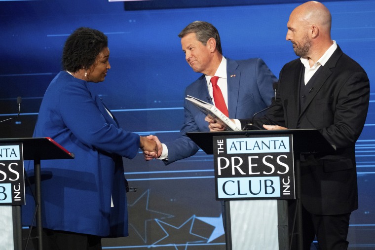 Democratic challenger Stacey Abrams, left, shakes hands with Georgia Republican Gov. Brian Kemp as Libertarian challenger Shane Hazel stands, right, after the Loudermilk-Young debate series in Atlanta on Monday, Oct. 17, 2022.