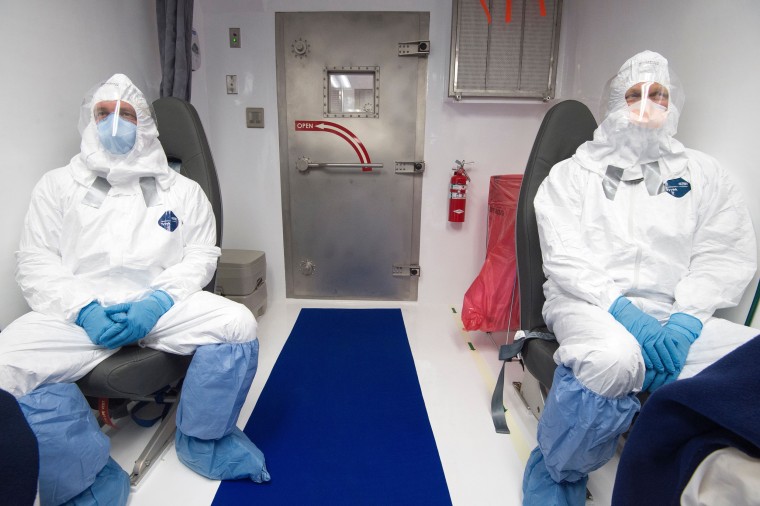 Members of a medical team monitor simulated patients infected with Ebola inside a Containerized Bio-Containment System (CBCS) during a shake-down exercise at Dulles International Airport in Virginia. 