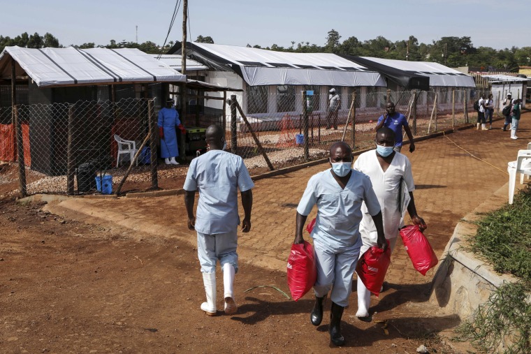 Medical attendants walk outside the Ebola isolation section of Mubende Regional Referral Hospital, in Mubende, Uganda 