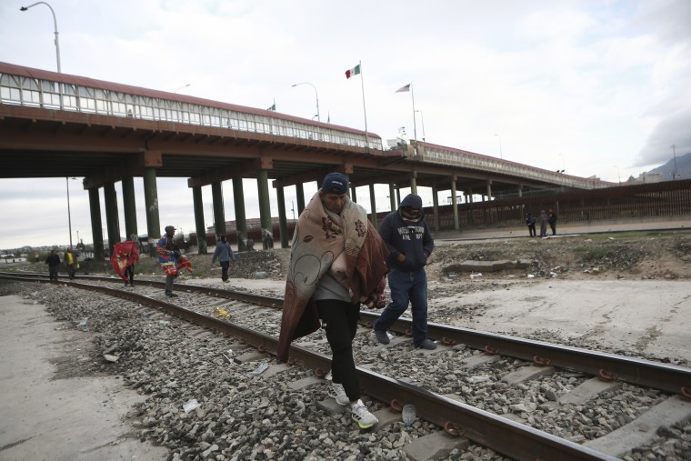 Venezuelan migrants walk near a bridge that crosses the Rio Grande River, in Ciudad Juarez, Mexico