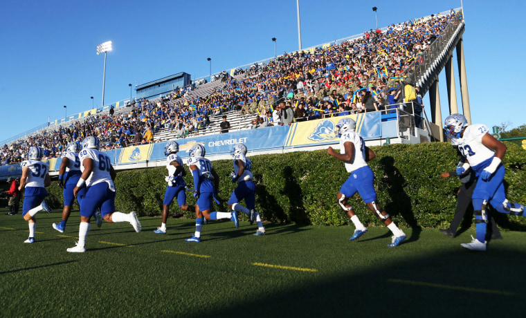 Members of the Hampton University football team take the field 