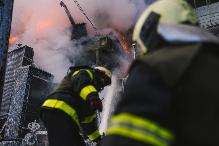 Firefighters tackle a blaze after Russian shelling hit critical infrastructure targets in Kyiv on Tuesday. 