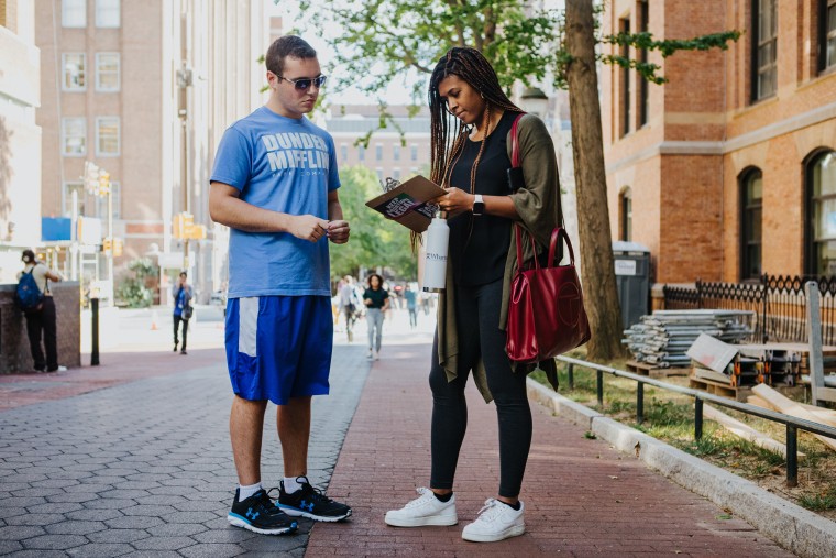 Coby Rich, 20, a junior at the UPenn, helps Chelsea Perry, 30, an MBA student at the Wharton School of Business, register to vote in Pennsylvania during a voter drive on campus in Philadelphia on Aug. 31, 2022.