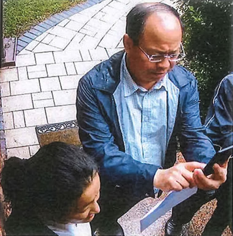 According to home surveillance footage, Guanyang An, left, and Weidong Yuan were at the residence of a victim, taking photographs of the residence and looking through their mail, according to the indictment.