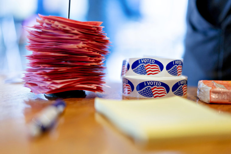 Pink voter count slips sit in a stack next to "I Voted" stickers at a polling station inside the clubhouse at Currie Park Golf Course in Wauwatosa, Wisc., on Nov. 6, 2018.