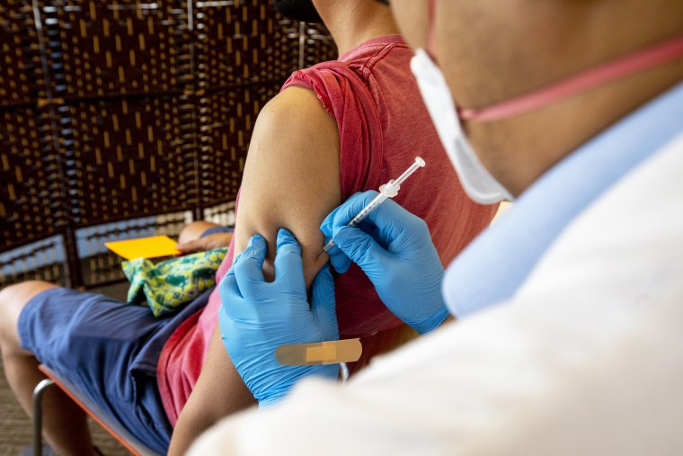 A health worker administers a dose of the monkeypox vaccine at a vaccination site