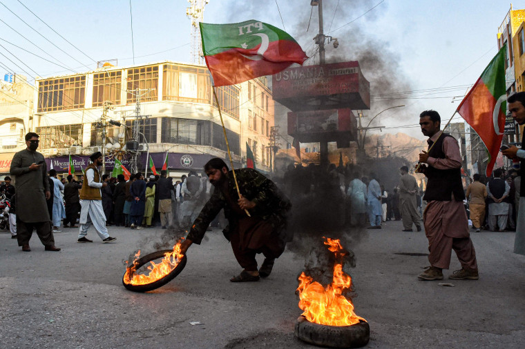 Activists of Pakistan Tehreek-e-Insaf party burn tires during a protest