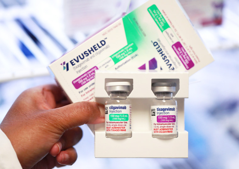 A person holds vials of Evusheld and its packaging