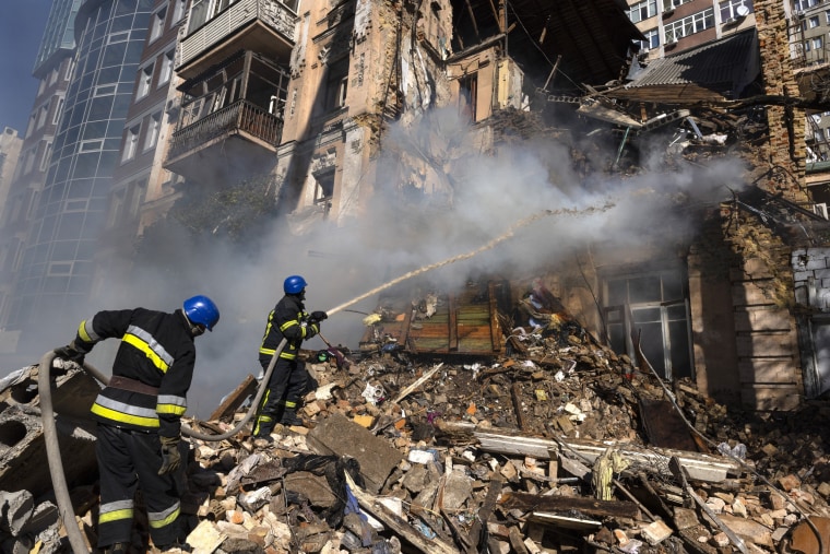 Firefighters work to put out a fire in residential building after a "kamikaze drone" attack