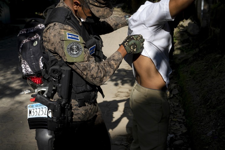 An army soldier frisks a motorcyclist at a checkpoint outside Comasagua, El Salvador, Thursday, Oct. 6, 2022. Combined army and police forces extended search and capture operations for gang members to the department of La Libertad, which authorities hold responsible for most of the crimes committed in the country.